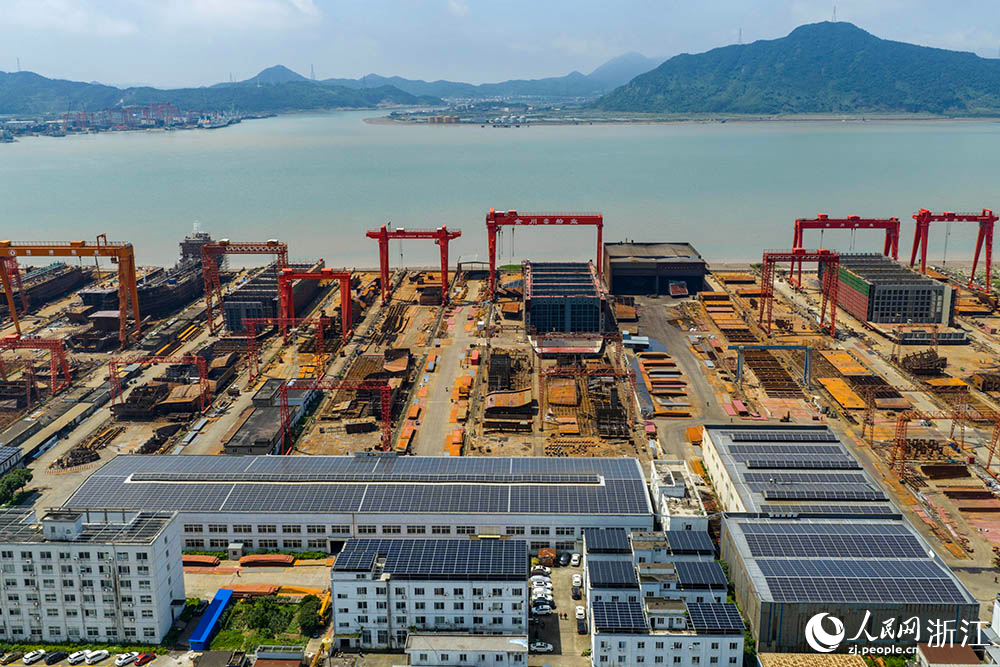 在浙江省寧波市象山縣石浦鎮打鼓峙臨港裝備制造基地，巨大的龍門吊緩緩移動，吊臂車在船體間穿梭自如，呈現一派熱火朝天的生產景象。人民網 章勇濤攝