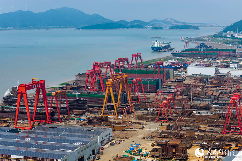 在浙江省寧波市象山縣石浦鎮打鼓峙臨港裝備制造基地，巨大的龍門吊緩緩移動，吊臂車在船體間穿梭自如，呈現一派熱火朝天的生產景象。人民網 章勇濤攝