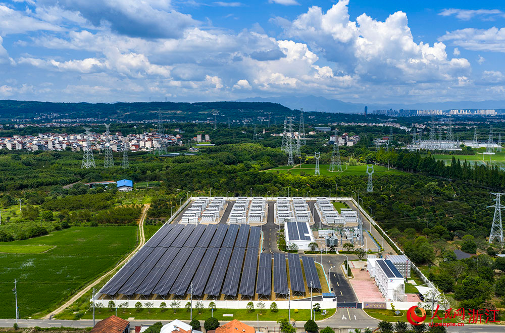陽光下的光伏板陣列熠熠生輝，與一排排白色儲能電池整齊排列，共同構成蓄勢待發的“電力糧倉”。人民網 章勇濤攝