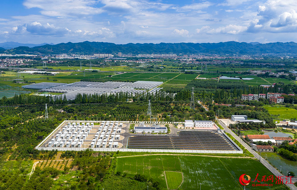 陽光下的光伏板陣列熠熠生輝，與一排排白色儲能電池整齊排列，共同構成蓄勢待發的“電力糧倉”。人民網 章勇濤攝