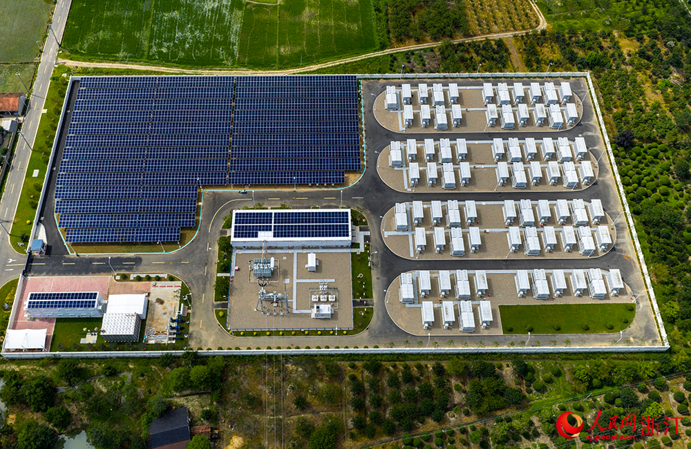 陽光下的光伏板陣列熠熠生輝，與一排排白色儲能電池整齊排列，共同構成蓄勢待發的“電力糧倉”。人民網 章勇濤攝