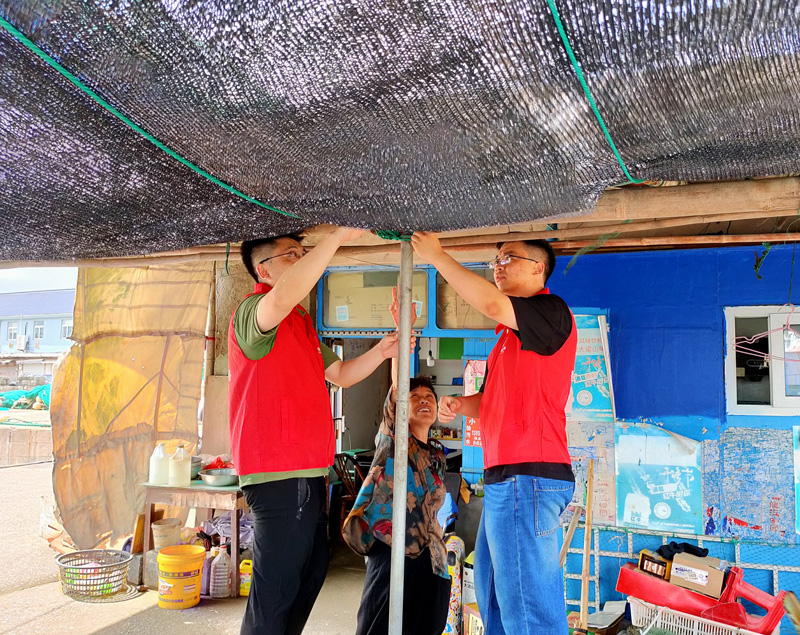 “香溢”志愿者在臺風登陸前為零售戶加固棚架。梁佳菲攝