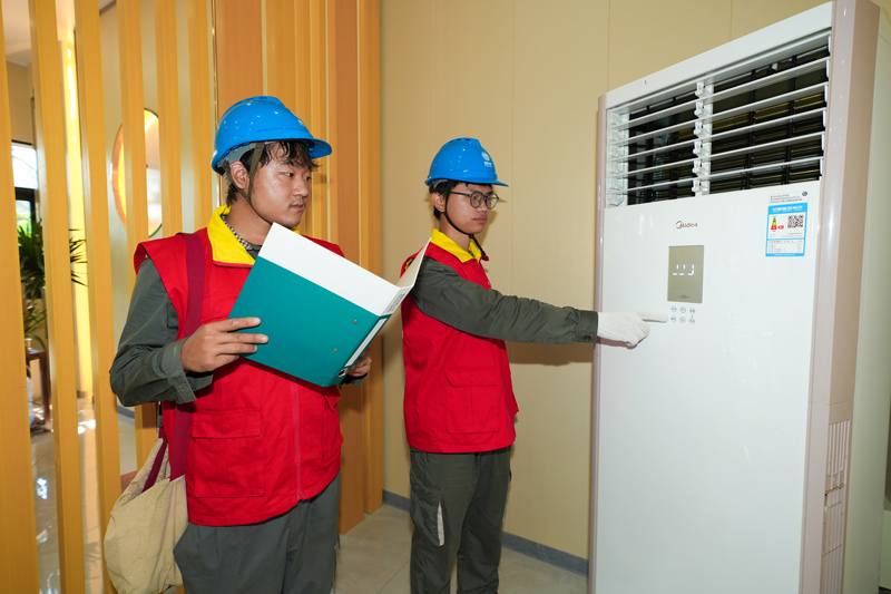 在居民家中，碳效服務工程師對增設了碳達人智能空調減碳模塊的空調設備進行調試。董振茂攝