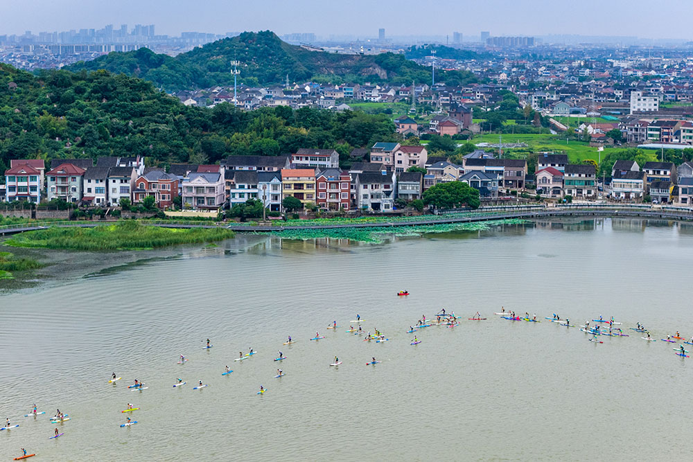 9月21日，在浙江省慈溪市觀海衛鎮，一塊塊色彩斑斕的槳板與鄉村的白墻黛瓦、遠山碧水交織成一幅動感十足的現代風景畫。人民網 章勇濤攝
