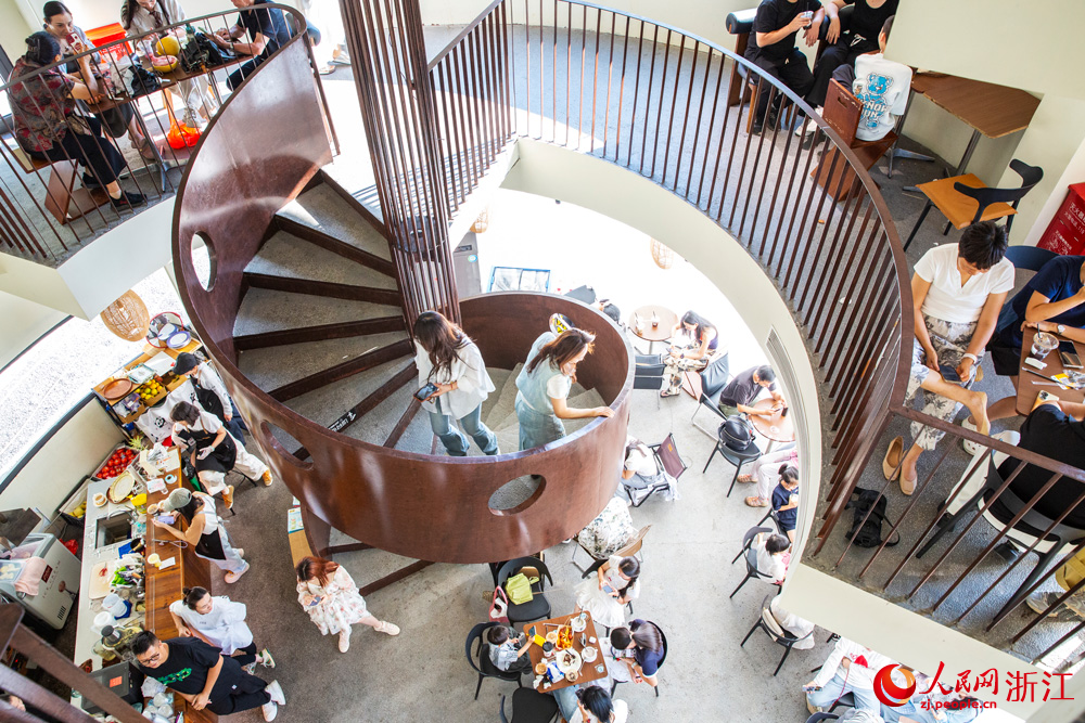 10月7日，浙江省溫州市蒼南縣金鄉鎮石砰碼頭，由擁有數十年歷史的老油庫改造而成的咖啡館內，游客們喝咖啡、品書香、賞海景，盡享假日休閑時光。人民網記者 葉賓得攝