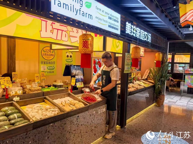 孫放在剪子股菜市里的攤位，經營自家農場的蔬果。人民網 李欣陽攝