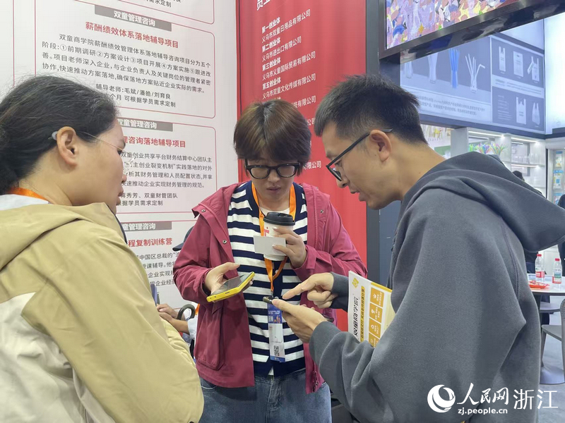 客商與雙童商學院工作人員互加聯系方式。人民網記者 王麗瑋攝